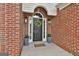 Inviting front entrance with a decorative wreath, potted plants, and a brick facade creating a warm welcome at 215 Murphy Creek Ln, Fayetteville, GA 30215