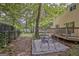 Enclosed backyard with a patio dining set, mature trees and lush lawn at 131 Sweetgum Rd, Peachtree City, GA 30269
