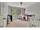 Bedroom with two windows, fan, neutral walls and carpeting, plus a crib at 131 Sweetgum Rd, Peachtree City, GA 30269