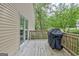 Wooden deck with a covered grill and sliding door access at 131 Sweetgum Rd, Peachtree City, GA 30269