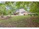View of a two-story home featuring yellow siding, a paved driveway, and well-kept landscaping at 131 Sweetgum Rd, Peachtree City, GA 30269