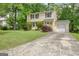 Charming yellow two-story house with attached garage, neat landscaping, and a concrete driveway at 131 Sweetgum Rd, Peachtree City, GA 30269