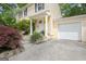 Home entrance featuring a paved driveway leading to the garage and well-maintained landscaping at 131 Sweetgum Rd, Peachtree City, GA 30269