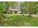 Well-maintained yellow home with a green lawn, mature trees, and a paved driveway leading to the garage at 131 Sweetgum Rd, Peachtree City, GA 30269
