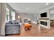 Sun-drenched living room with hardwood floors, recessed lights, and a cozy fireplace at 131 Sweetgum Rd, Peachtree City, GA 30269