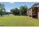 Spacious, well-manicured backyard with mature trees leading to a serene lake, perfect for outdoor activities at 70 Lake Charles Xing, Covington, GA 30016
