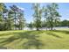 Expansive backyard with lush lawn and scenic views of the tranquil lake at 70 Lake Charles Xing, Covington, GA 30016