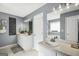 Bright bathroom features a double sink vanity with storage, a mirror, and a soaking tub at 70 Lake Charles Xing, Covington, GA 30016