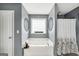Spa-like bathroom featuring a soaking tub with jacuzzi jets, a window, and stylish decor at 70 Lake Charles Xing, Covington, GA 30016