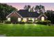 Charming red brick home featuring a well-manicured lawn and mature landscaping at 70 Lake Charles Xing, Covington, GA 30016
