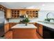 Well-lit kitchen with an island, stainless steel appliances, wooden cabinets, and marble countertops at 70 Lake Charles Xing, Covington, GA 30016