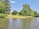 Picturesque lake view surrounded by mature trees and a glimpse of a home at 70 Lake Charles Xing, Covington, GA 30016