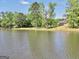 Scenic view of a tranquil lake, lush trees, and a home in the background at 70 Lake Charles Xing, Covington, GA 30016