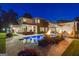 A modern home featuring a luxurious pool, fire bowls, and beautifully landscaped backyard at dusk at 159 Sims Rd, Tyrone, GA 30290