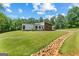 This modern home has a long, grassy lawn with a decorative rock drainage feature at 159 Sims Rd, Tyrone, GA 30290