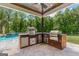 A covered outdoor kitchen is equipped with a grill, pizza oven, and stainless steel cabinetry at 159 Sims Rd, Tyrone, GA 30290