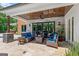 Covered stone patio with comfortable seating, ceiling fan, and view to the backyard at 159 Sims Rd, Tyrone, GA 30290