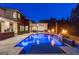 A gorgeous in-ground pool with blue lighting and fire bowls sits outside this modern home at 159 Sims Rd, Tyrone, GA 30290