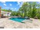 Backyard with luxurious pool featuring a stone surround, seating, and landscaping at 159 Sims Rd, Tyrone, GA 30290
