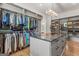Spacious walk-in closet with custom shelving, marble-topped island, wood floors, and modern lighting fixture at 159 Sims Rd, Tyrone, GA 30290