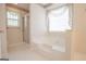 A bathroom with a shower, a soaking tub, and a window with a sheer curtain at 2180 Briarwood Ct, Villa Rica, GA 30180