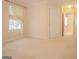 A bedroom is shown with neutral carpeting, a window dressed with sheers, and a door to an en suite bathroom at 2180 Briarwood Ct, Villa Rica, GA 30180
