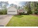 Charming one story home with manicured front lawn and two car garage surrounded by mature trees at 2180 Briarwood Ct, Villa Rica, GA 30180