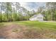 Secluded property with expansive lawn area partially surrounded by dense trees, providing privacy and natural beauty at 2180 Briarwood Ct, Villa Rica, GA 30180