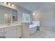 Bathroom with double vanity, large window, and soaking tub at 100 Bre Dr, Fayetteville, GA 30214