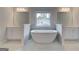 Bright bathroom featuring a soaking tub, separate vanities, and a large window at 100 Bre Dr, Fayetteville, GA 30214