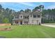 Inviting two-story home featuring a well-manicured lawn, neutral color scheme, and complementary landscaping at 100 Bre Dr, Fayetteville, GA 30214