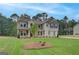 Inviting two-story home featuring a well-manicured lawn, neutral color scheme, and complementary landscaping at 100 Bre Dr, Fayetteville, GA 30214