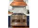 Updated kitchen with a large stainless steel range and a custom wood range hood at 508 Caxton Ct, Peachtree City, GA 30269