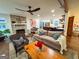 Spacious living room with a stone fireplace, hardwood floors, and an open concept design connecting to the kitchen at 508 Caxton Ct, Peachtree City, GA 30269