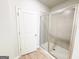 This neutral bathroom has a glass shower enclosure, light tile, and a white door that adds a clean and modern feel at 5096 Cumberland Ct # 96, Villa Rica, GA 30180