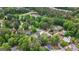 Stunning aerial view of residential area with lush trees, a pond, and multiple swimming pools at 150 Rockspray Rdg, Peachtree City, GA 30269