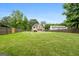 Expansive backyard with lush green grass, a wooden fence, and mature trees at 150 Rockspray Rdg, Peachtree City, GA 30269