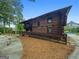 Rustic log cabin featuring a ramp, balcony, and charming architectural details set in a serene, wooded landscape at 150 Rockspray Rdg, Peachtree City, GA 30269