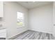 Bright and airy room featuring wood-look floors, a large window, and neutral wall paint at 281 Limestone Circle, Conyers, GA 30013