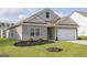 Charming home with a two-car garage, complemented by green grass and beautiful landscape at 281 Limestone Circle, Conyers, GA 30013