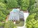 Aerial view showcasing a luxurious home with a pool and a circular driveway surrounded by lush greenery at 602 Embassy Ct, Peachtree City, GA 30269