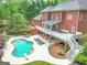 Aerial view of a backyard featuring a beautiful pool, spacious deck, and lush landscaping at 602 Embassy Ct, Peachtree City, GA 30269