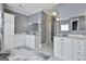 Bright bathroom with marble floors, double sinks, and white cabinets at 602 Embassy Ct, Peachtree City, GA 30269