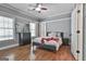 Comfortable bedroom featuring hardwood floors, a ceiling fan, and natural light from the windows at 602 Embassy Ct, Peachtree City, GA 30269