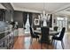 Elegant dining room featuring dark walls, wood floors, and a stunning crystal chandelier at 602 Embassy Ct, Peachtree City, GA 30269