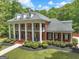 Stunning two-story brick home featuring a columned front porch and beautifully landscaped front yard at 602 Embassy Ct, Peachtree City, GA 30269