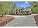 Grand two-story brick home with a striking columned facade, circular driveway and lush landscaping at 602 Embassy Ct, Peachtree City, GA 30269