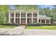 Elegant brick home with a columned front porch, black shutters and a well-manicured lawn creating curb appeal at 602 Embassy Ct, Peachtree City, GA 30269