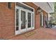 Elegant glass front doors welcome you into this home with a brick floor and inviting rocking chairs at 602 Embassy Ct, Peachtree City, GA 30269