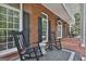Charming front porch featuring rocking chairs and a brick floor, perfect for relaxing and enjoying the outdoors at 602 Embassy Ct, Peachtree City, GA 30269